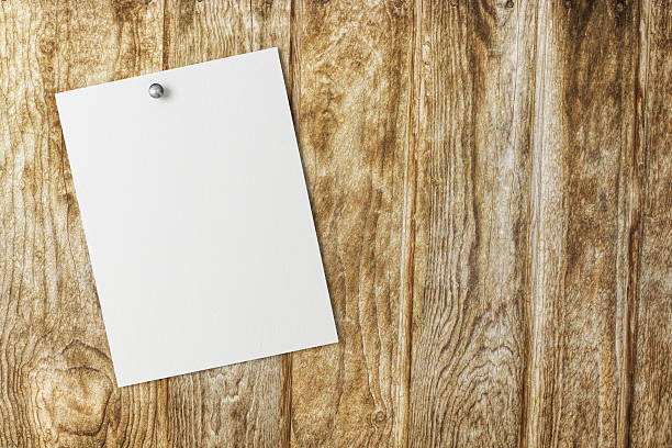 istock Blank white paper on a wood background 473436144