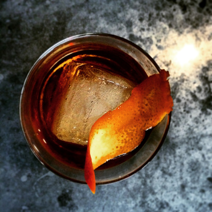 Overhead shot of craft whiskey cocktail on marble bar