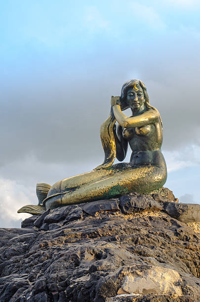 The Golden Mermaid statue on a big rock in Songkhla, ThailandThe Golden Mermaid statue on a big rock in Songkhla, Thailand