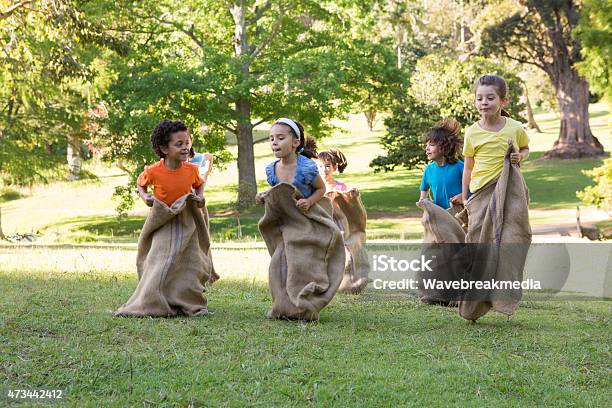 Children Having A Sack Race In Park Stock Photo - Download Image Now - Child, Sports Race, Natural Parkland