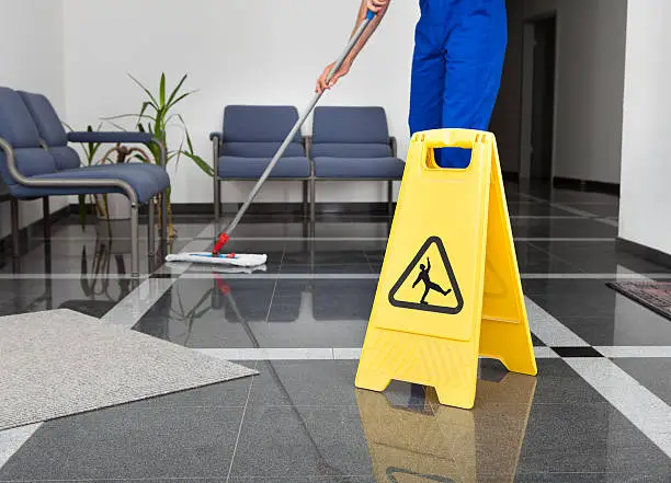 Photo of Man With Mop And Wet Floor Sign
