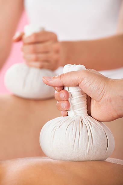 istock Couple Receiving Massage With Herbal Compress Stamps At Spa 473443922