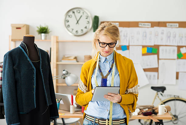 istock Fashion designer using a tablet in a cluttered room 473445236