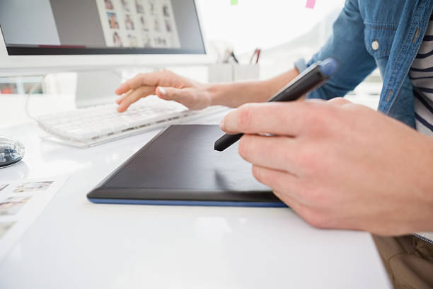 istock Hands of designer typing on keyboard and using digitizer 473445540