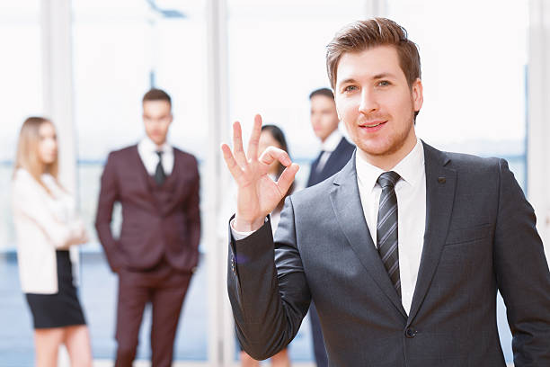 istock Young business man standing in front of his co-workers 473446038