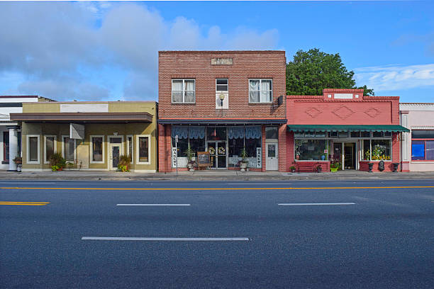 Main Street Stores in of Old Small Town Retail stores in small town America with an empty highway. small town stock pictures, royalty-free photos & images