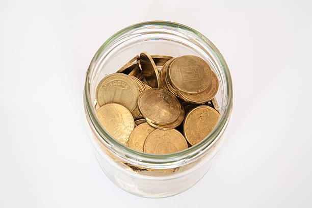 istock coin in money jar 473452538