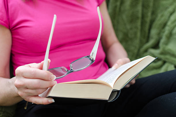 istock Woman reading a book on a couch 473453516