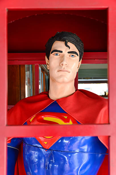 A business man in suit and tie wears a superhero cape and mask and flies through the clouds, his fist raised in the air as he looks to fight for justice.  Horizontal with copy space.