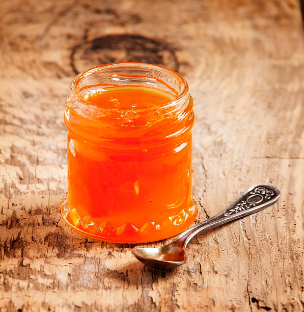 istock Apricot jam in a jar on the table, selective focus 473458282