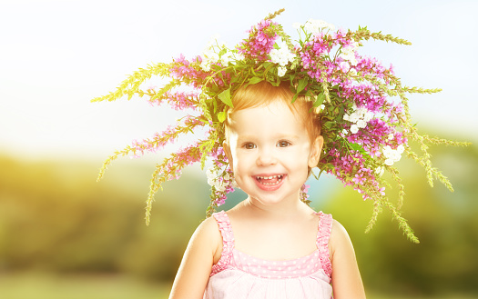 face happy little baby girl child in summer wreath