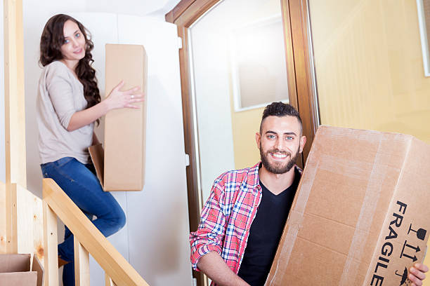 istock young couple carrying the boxes in new house 473458970