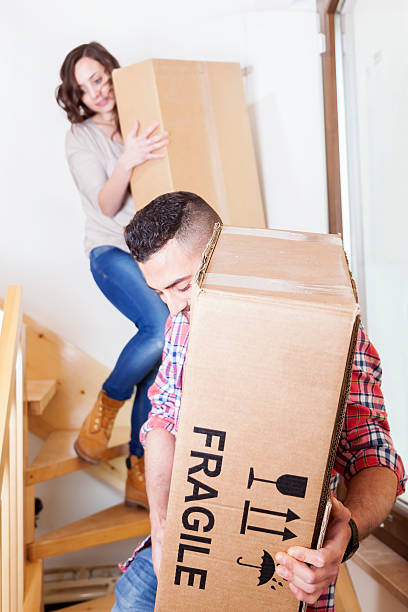 istock young couple carrying the boxes in new house 473458980