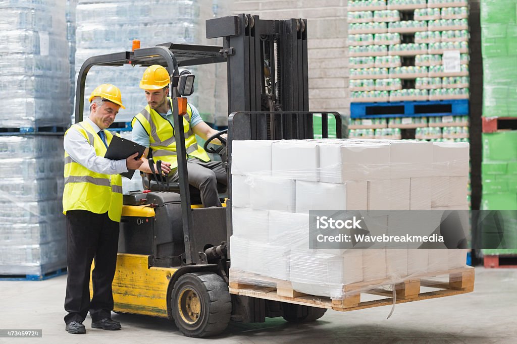 Forklift driver talking with his manager Forklift driver talking with his manager in a large warehouse 20-24 Years Stock Photo