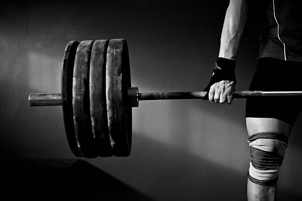 Man practising weightlifting a photo of a man lifting barbell and disks clean and jerk stock pictures, royalty-free photos & images