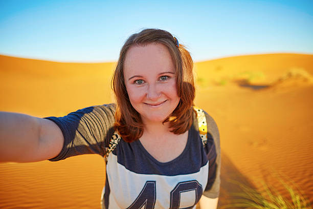istock Happy tourist taking selfie in Sahara 473459806