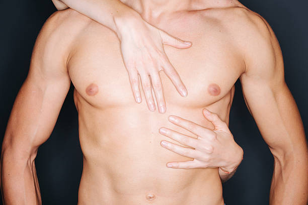 Woman's seductive hands pressing against man's bare chest in intimate moment