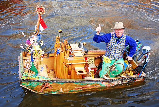 Amsterdam, The Netherlands- April 23, 2015: Musician Reinier Spijkens sending greetings from his music boat where he plays music on the canals of Amsterdam for free.