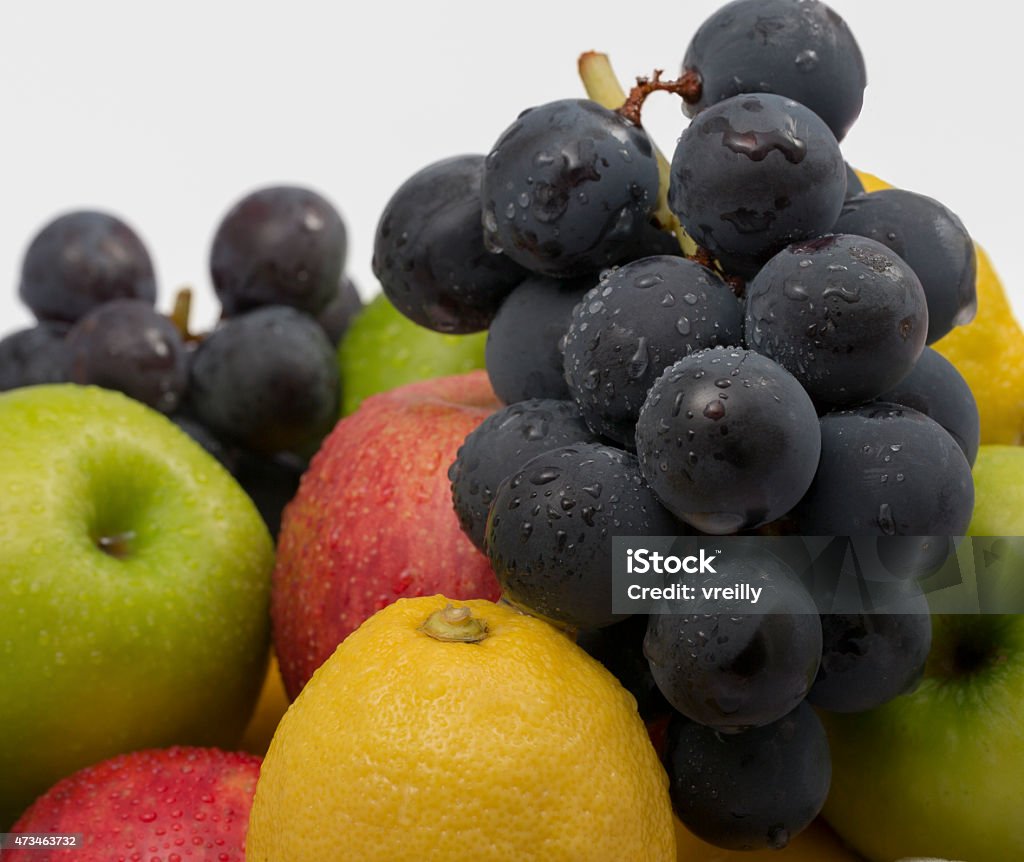 Mixed Fresh Fruit A pile of fresh fruit including red and green apples, lemons,and grapes with top white space 2015 Stock Photo