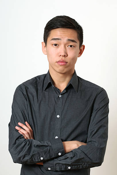 istock Romantic young Asian man with crossed hands looking at camera 473469926