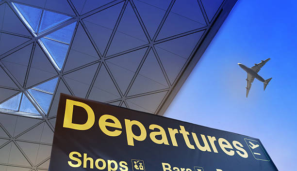 Departure sign in airport against of blue sky and plane in the sky