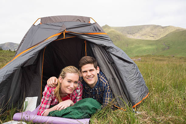 istock Happy couple lying in their tent and looking at camera 473471366