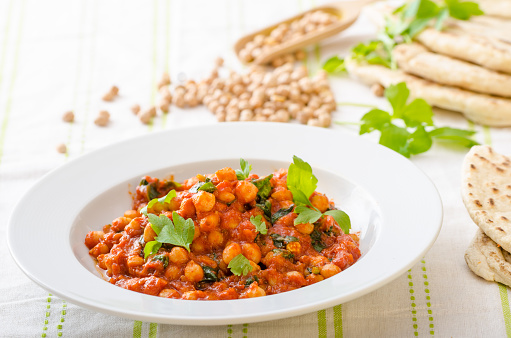 Spinach chickpea curry, fresh and healthy, with herbs and lebanese bread