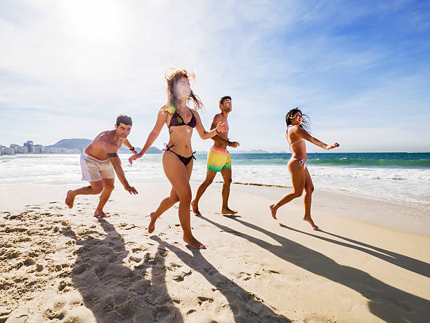 istock Cheerful people chasing on the beach and having fun. 473474086