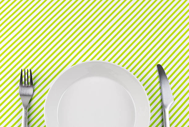 Old crockery on vintage 60s or 70s tablecloth.  View from above with copy space. High quality indoor shot. Copy space for your text or logo. Dish has scratches and looks used.