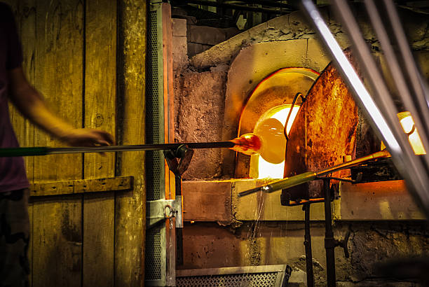 Murano Glassblowing artisan at work in a crystal glass workshop in Murano island Venice Lagoon.Murano glassmakers use the same tools as their ancestors have thousands of years ago. hand blown glass stock pictures, royalty-free photos & images