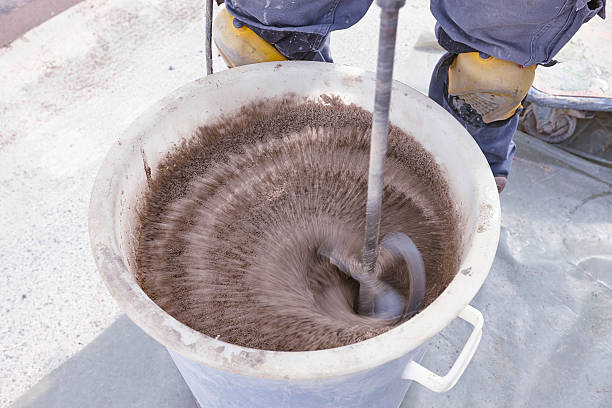 istock Mixing cement close up on white bucket 473482480