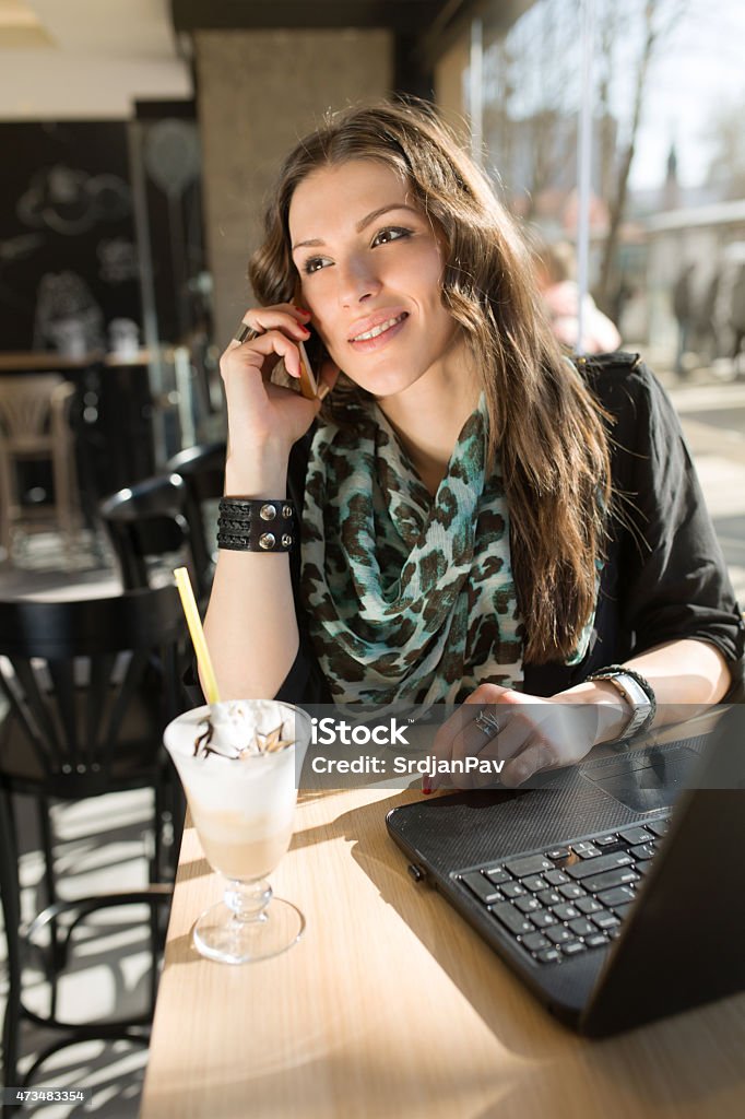 Working Best at Coffee Shops Beautiful young business woman talking on a mobile phone, having a coffee break in a local internet cafe. 20-29 Years Stock Photo