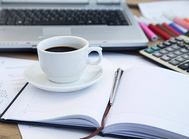 istock Coffee Cup at Office over Financial Papers and Agenda.Coffee Bre 473486934