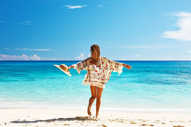 frau mit sarong am strand auf den seychellen - women sarong beach white stock-fotos und bilder