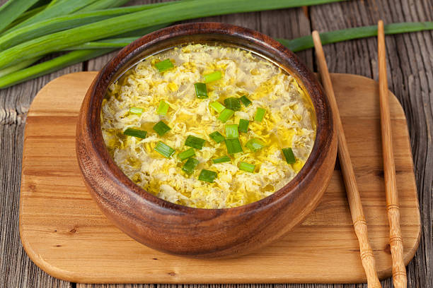 Vegetarian traditional asian drop egg soup with broth in wooden stock photo