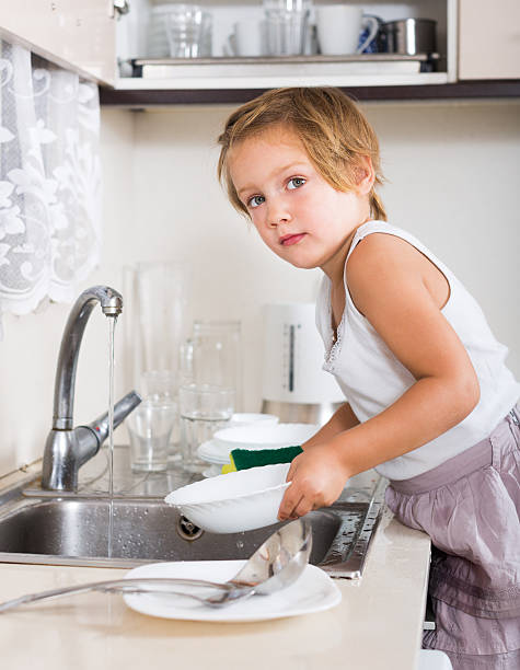 istock Small child washing dishes 473495768