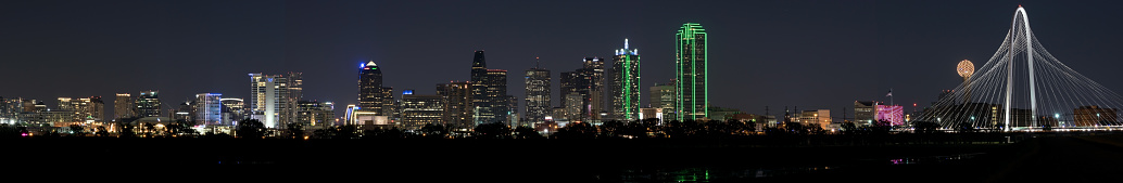 Panorama of the lit up skyline of Dallas, Texas at night as seen from the Trinity River Levee