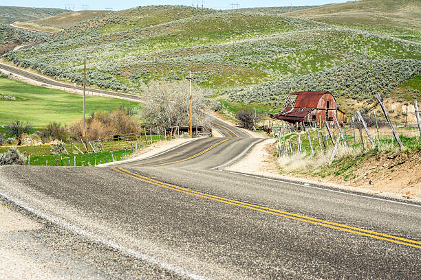 istock Winding country raod and red barn 473497678