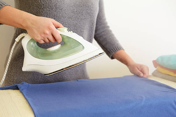istock Woman ironing blue polo shirt 473498154