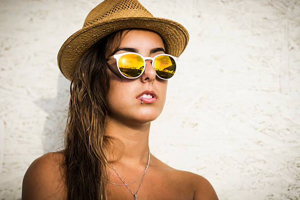 Portrait of young woman posing at the beach with sunglasses