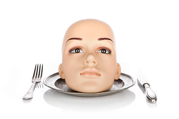Head of a plastic mannequin lying on a plate. White background