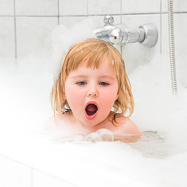 istock cute two year old baby bathes in a bath with 473503238