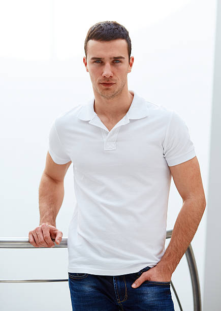 istock Man in a polo shirt stands leaning on railing 473505716