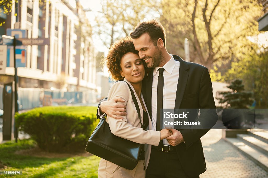 Outdoor portrait of flirting elegant couple Outdoor portrait of happy elegant couple - afro amercian woman and caucasian man, embracing at sunset.  2015 Stock Photo