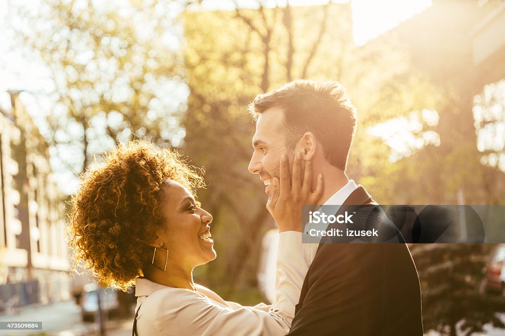 Outdoor portrait of flirting elegant couple Outdoor portrait of cheerful, elegant couple - afro amercian woman and caucasian man at sunset. Close up of faces. Businesswoman Stock Photo