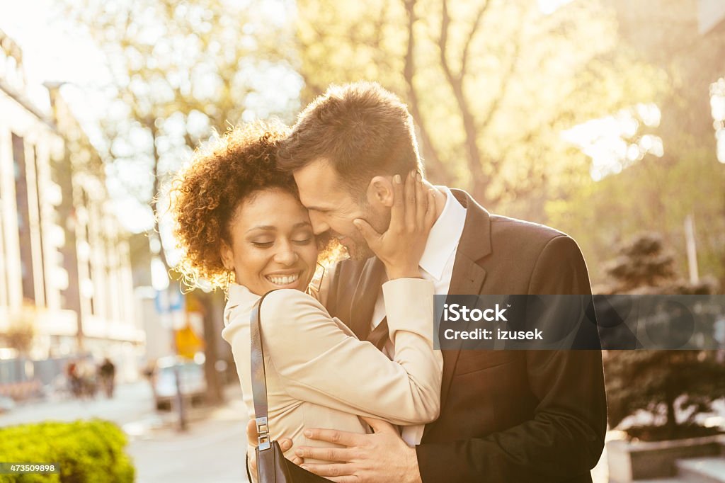 Outdoor portrait of flirting elegant couple Outdoor portrait of cheerful, elegant couple - afro amercian woman and caucasian man embracing at sunset. Close up of faces. Elegance Stock Photo