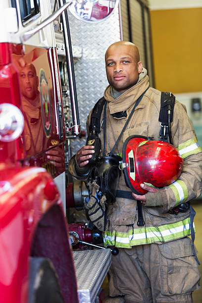 istock African American fire fighter standing next to truck 473517360