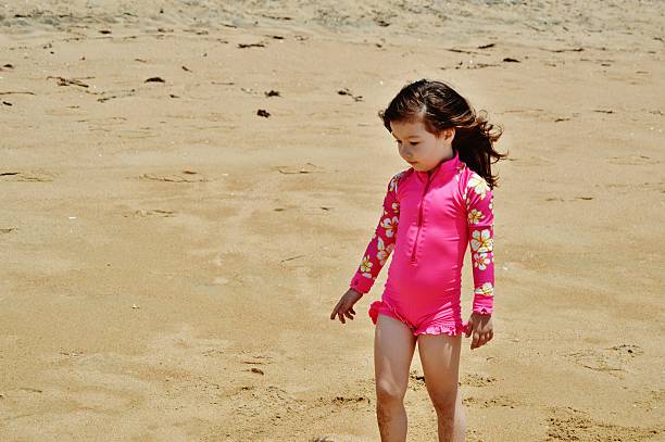 istock Little girl walking at the beach 473517950
