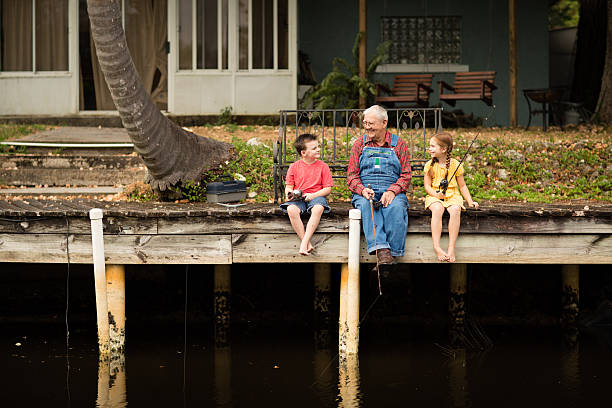 grandpa pescar en el muelle con bisnieto y granddaughter  - great grandson fotografías e imágenes de stock