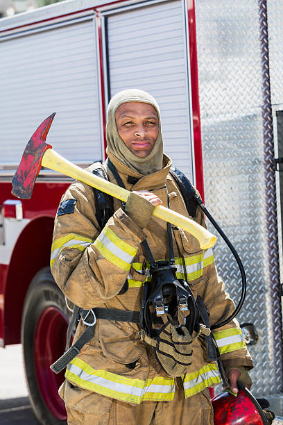 istock African American fire fighter carrying axe 473519604